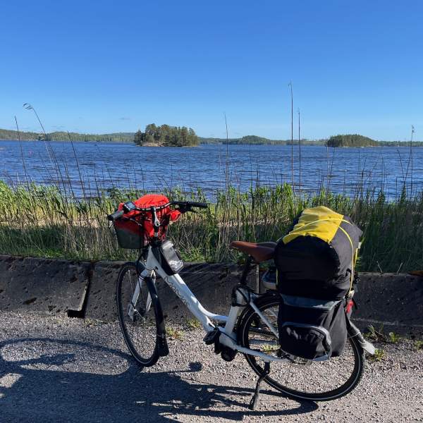 En ferdig oppakket sykkel som står foran en stor innsjø