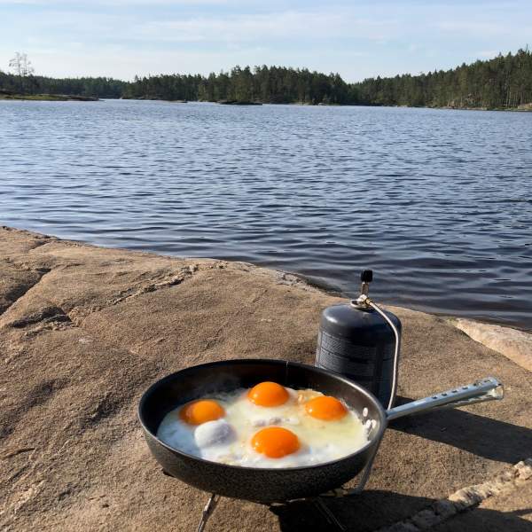 Primus med stekepanne med fire egg i