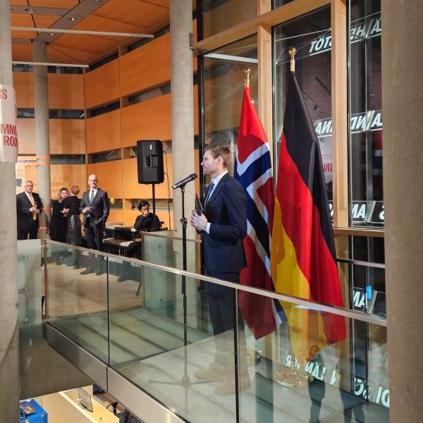 Landbruksministeren taler foran Norske / tyske flagget