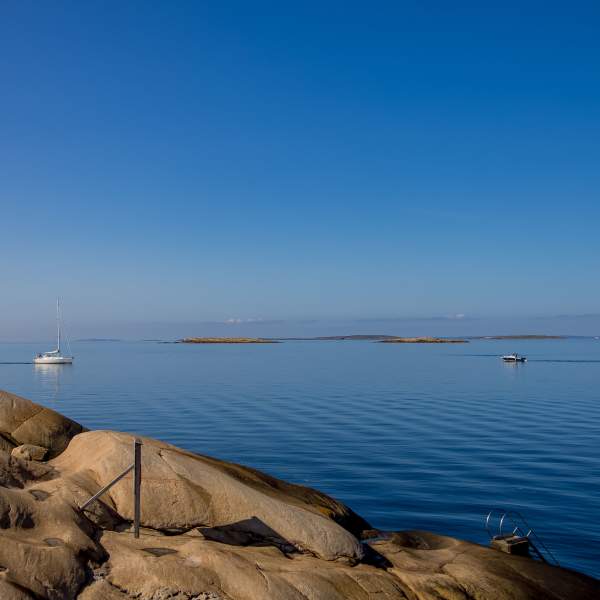 Blankslipte svaberg og blikkstille vann en solskinnsdag