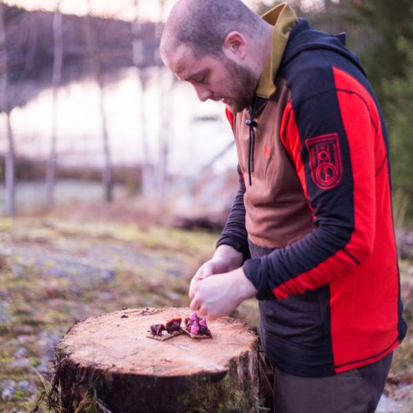 Mann forbereder gourmetmat i naturen