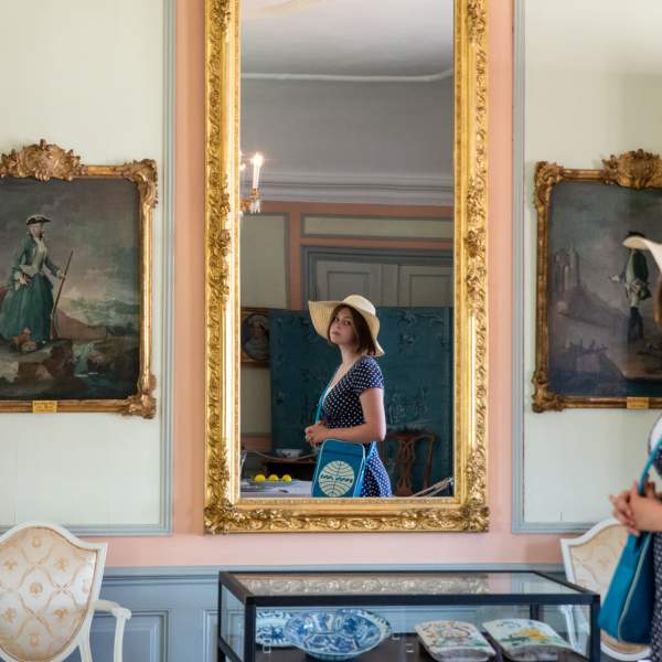 En jente som ser i et speil inne på Rød herregård i Halden.