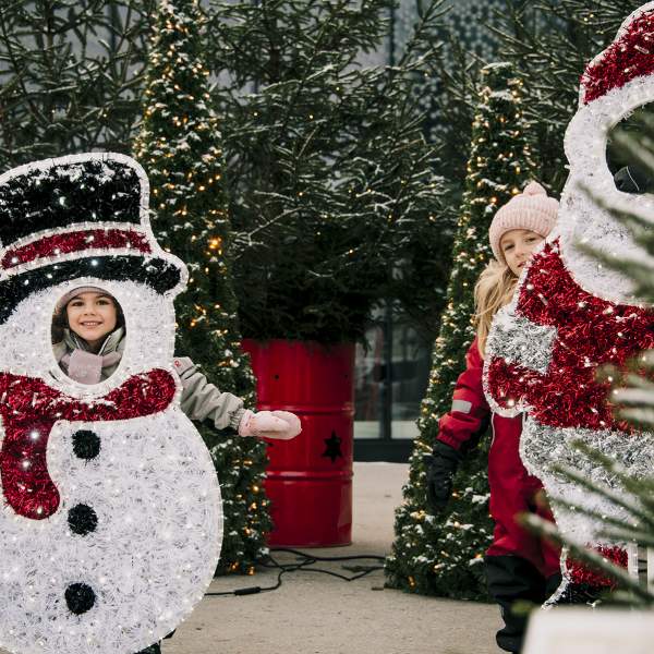 To jenter som leker ved julepynten på torget i Sarpsborg. Foto.