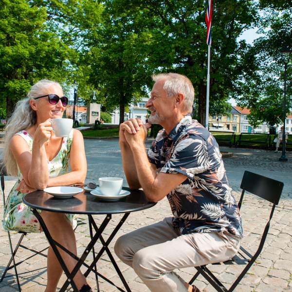 Par drikker kaffe på en fortauskafé i Halden