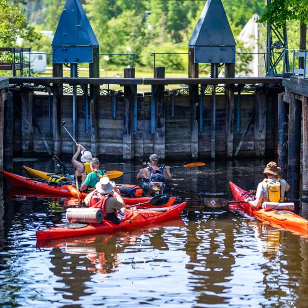 Fem kajakker venter på å bli sluset ned i Strømsfoss mølle