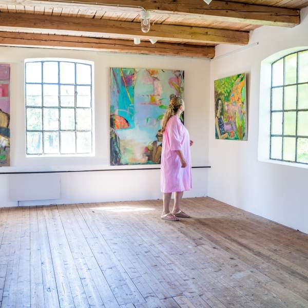 En dame kikker på bildene i galleri Strømsfoss
