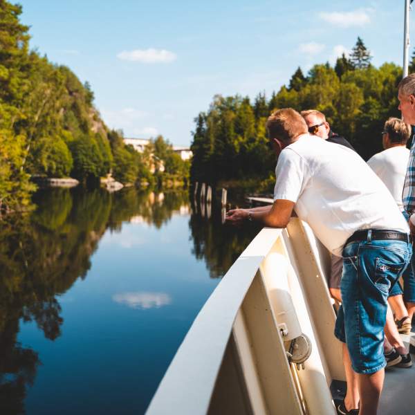 Fire personer står ved relingen på skipet, og ser utover Haldenkanalen