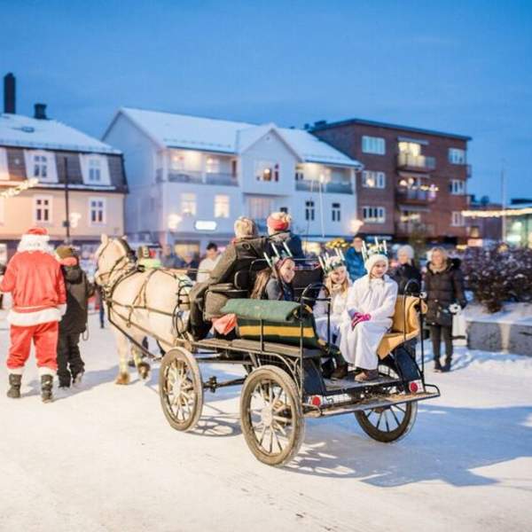 Nissen leier en hest med vogn i byen, hvor det sitter mange barn i vogna