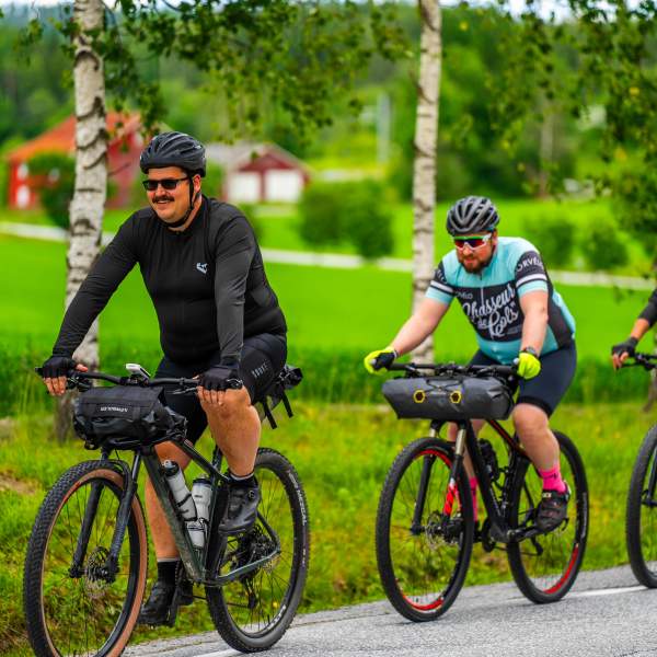 Syklister sykler gjennom frodig landskap