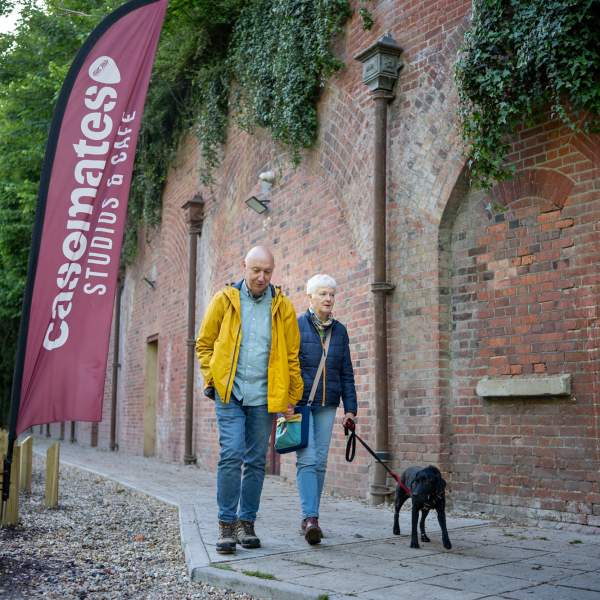 A couple with a black dog outside Casemates Studios