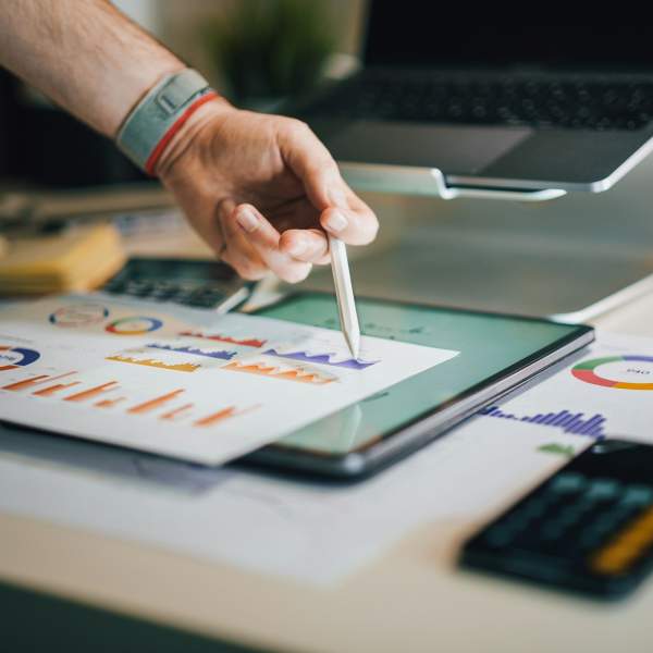 Photograph of a person looking over reports and graphs
