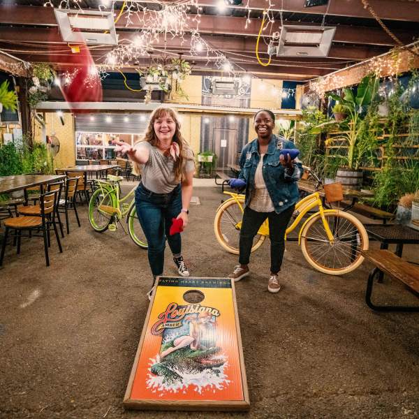 Two Friends Playing Cornhole at Flying Heart Brewery & Pub