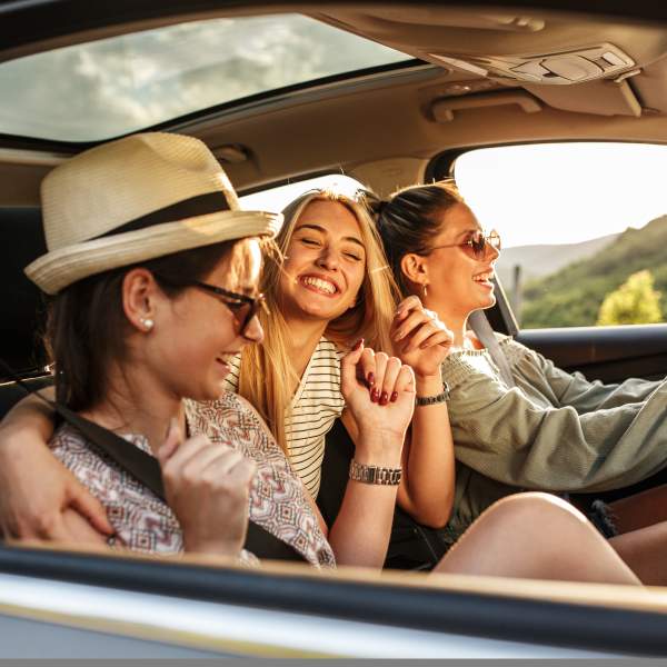 3 women driving - riding in car on a road trip