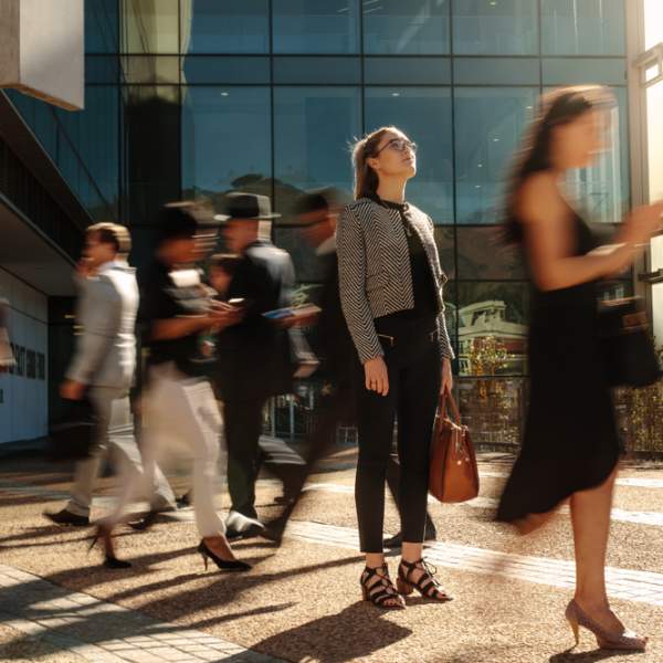 Woman standing while people walk past