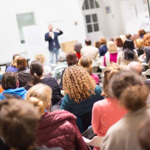 person speaking to seated audience