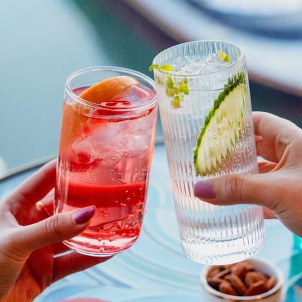People clinking cocktails together at HarBAR on 6th rooftop bar
