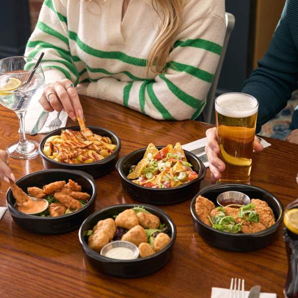 Group of friends eating small dishes at Yates