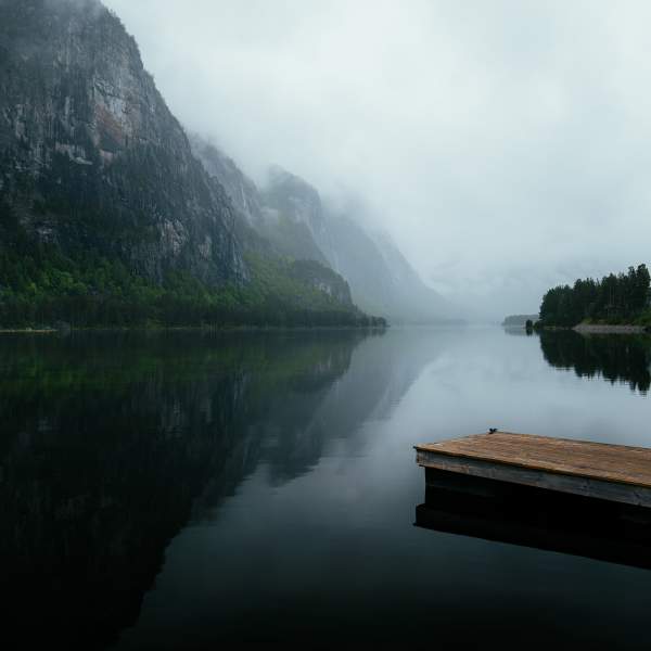 A dock in a lake in foggy weather