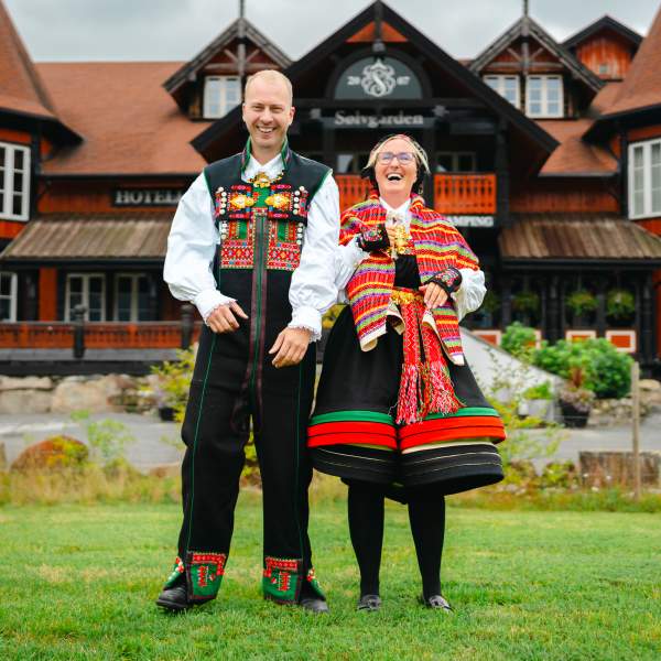 En kvinne og en mann i Setesdalsbunad foran Sølvgarden hotell