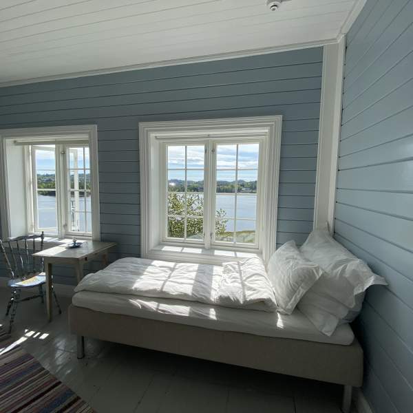 Soverom med seng og to vinduer