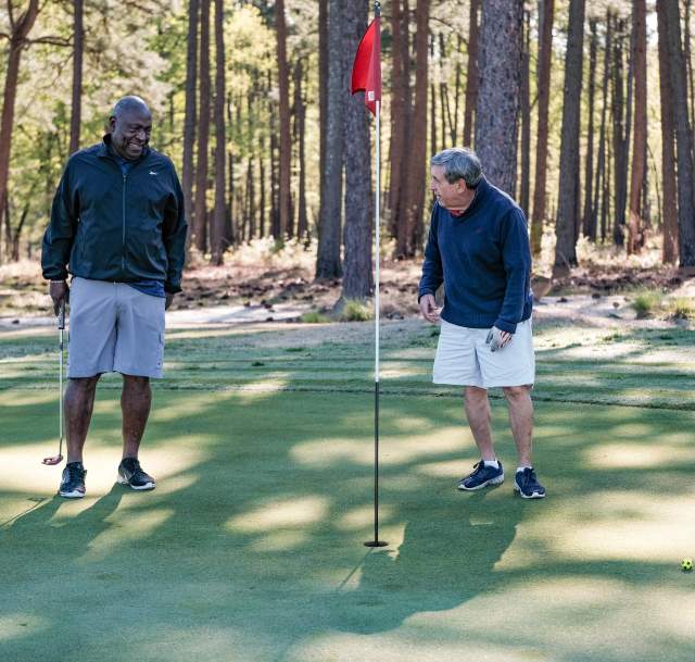 Two men laughing around a golf flag at Cumberland County's Bayonet Golf Course