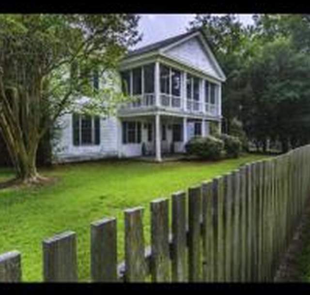James Rockefeller House at Carvers Creek State Park, a historic white home with a porch and wooden fence surrounded by trees.