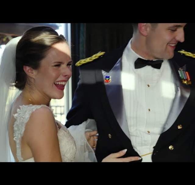 Bride and groom laughing together during their wedding in Cumberland County, NC, with the groom in a formal military dress uniform and the bride in a white gown and veil.