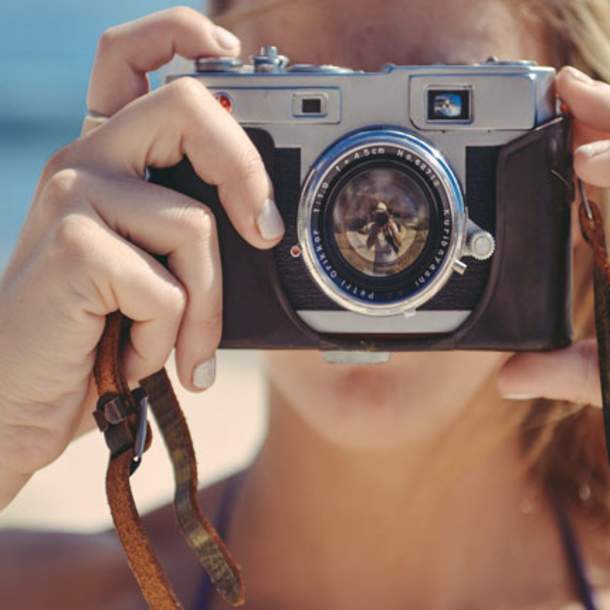 a woman with a camera on the beach