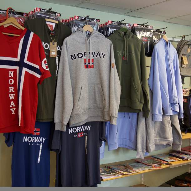 Genser og t-skjorter med norsk flagg og “Norway”-motiv i butikkhyllen.