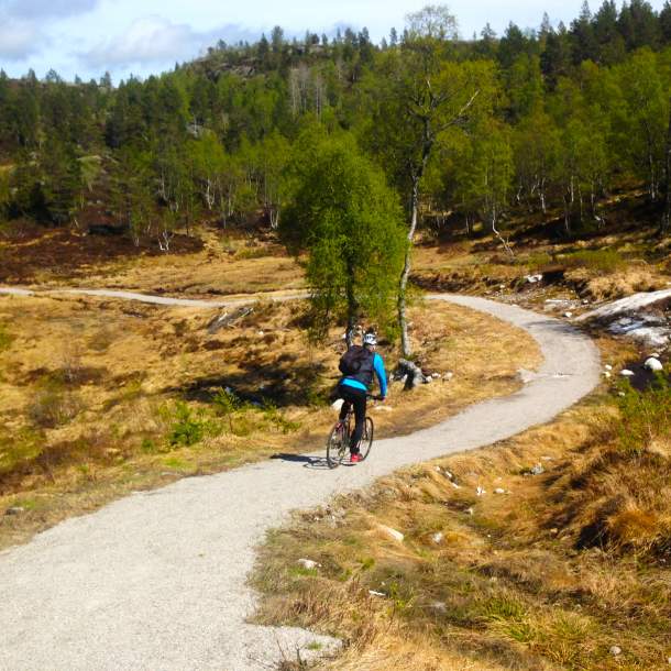 syklist på grusvei i skogen