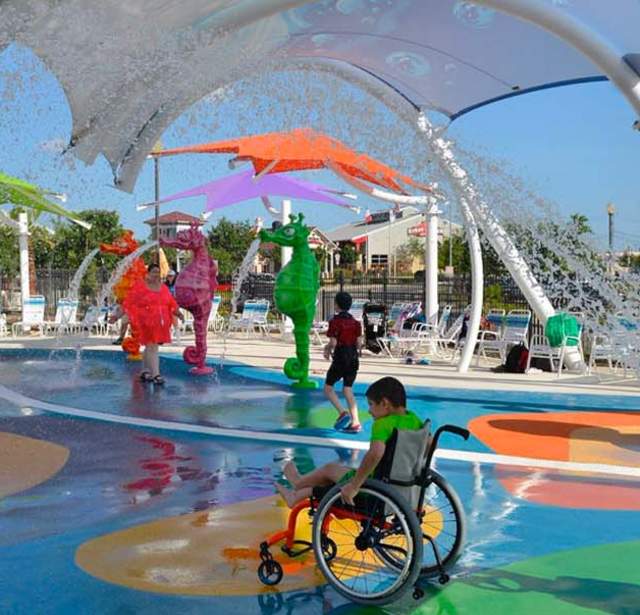 Person in wheelchair wheeling through waterpark