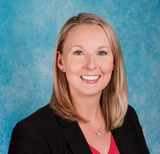 Blonde woman with blue eyes in a professional headshot.