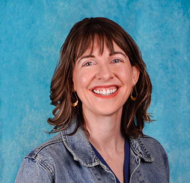 Woman's headshot with a blue background.