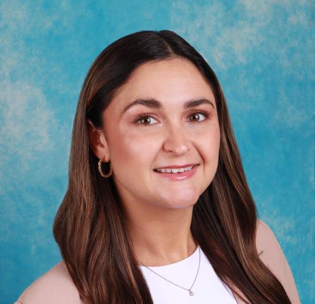 Woman's professional headshot with a blue background.