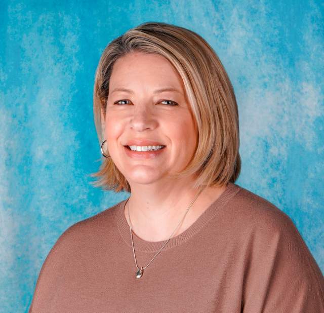 Woman's professional headshot on a blue background.