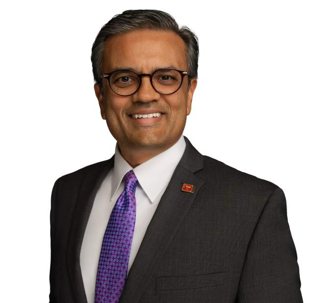 Vijay Patel in a suit and tie smiling into the camera posing for a headshot.