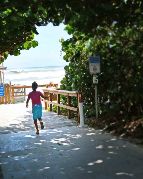Girl running sea grape arch Delray Beach Atlantic Ocean