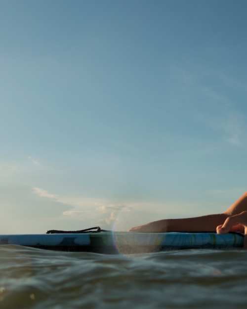 Naples beach scenes floating in Gulf of America on paddle boards child snorkeling child on boogie board setting sun in her face