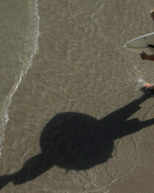A surfer prepares to brave the waves. Cocoa is a renowned among the hang-ten crowd, and even features an independent gallery showcasing surfer artwork.
