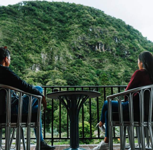 Couple drinking coffee on a terrace. The mountains of Cerro Punta are on the view
