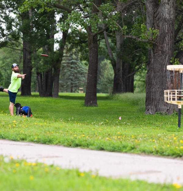man playing disc golf in a green park