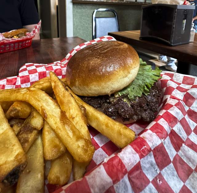 A burger and fries sits on a checkered parchment at a Restaurant in Fayetteville.