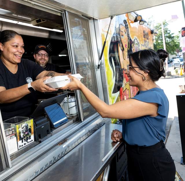 A young woman receives her food from a Fayetteville, NC food truck