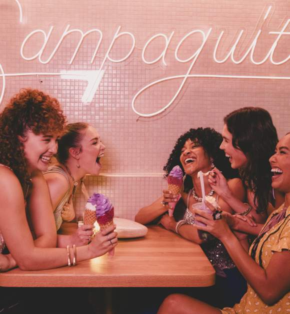A group of ladies sitting at a booth, laughing and eating ice cream at Sampaguita Ice Cream