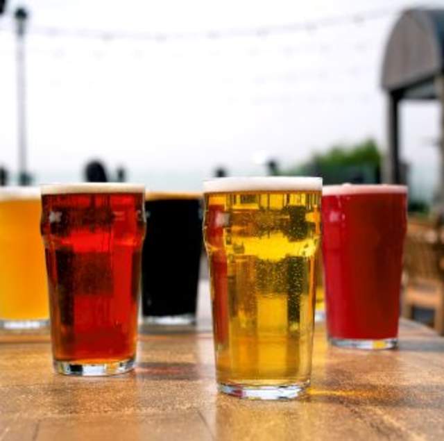 Several glasses of beer on a wooden table