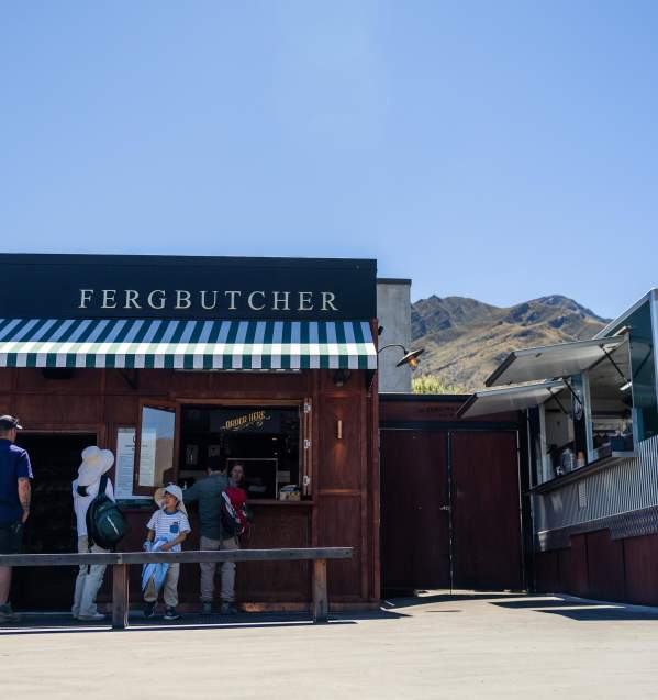 A group of people waiting for their order at Fergbutcher in Arrowtown on a beautiful blue bird day