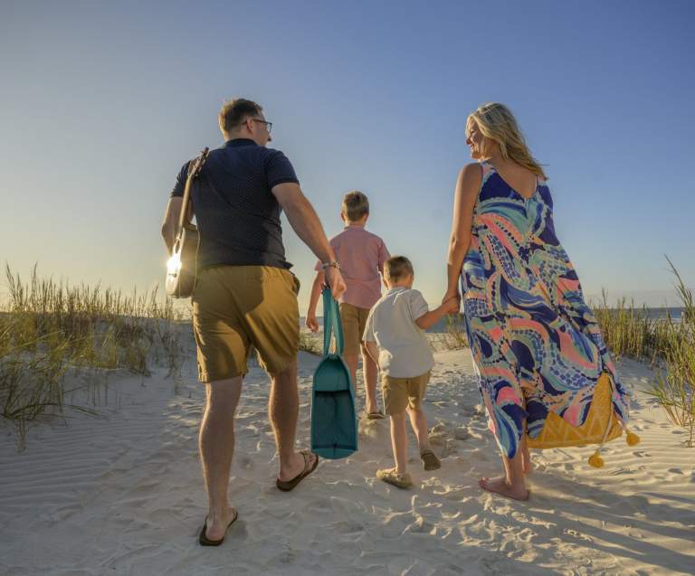 A family walks down to the beach