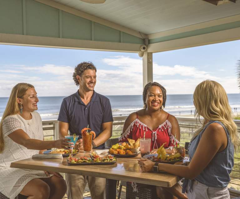 A group of friends dines oceanfront at Snooky's on the Water