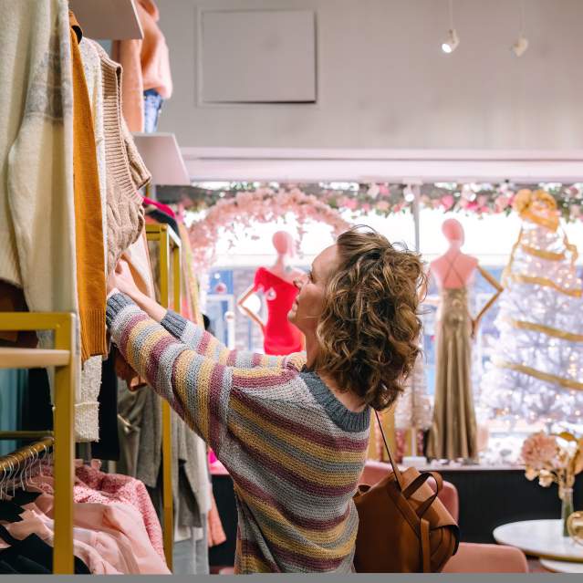 A woman shops in a boutique that sells women apparel at Christmas time.