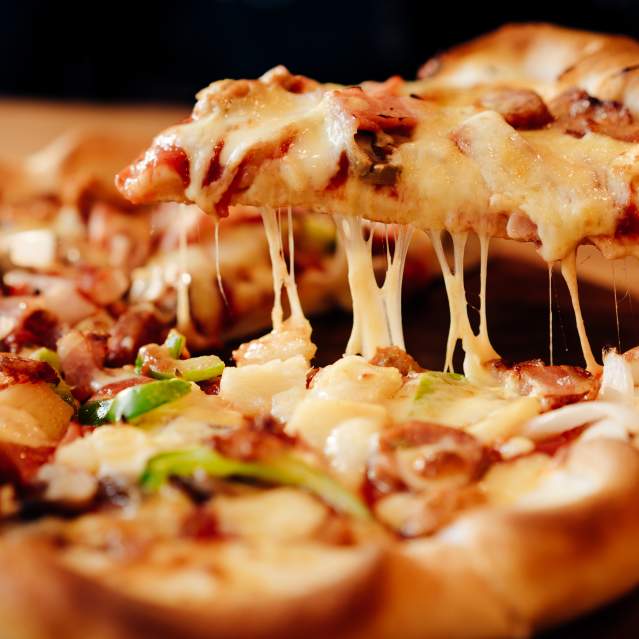Person Taking a Slice of Pizza with Cheese and Toppings,